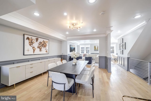 dining room with crown molding, a notable chandelier, and light hardwood / wood-style flooring