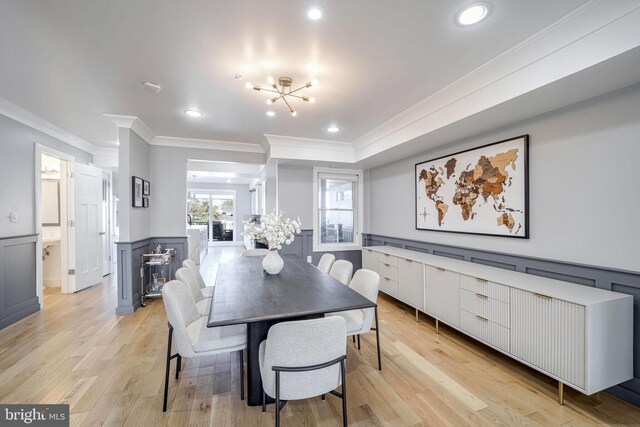 dining area featuring crown molding, a chandelier, and light wood-type flooring