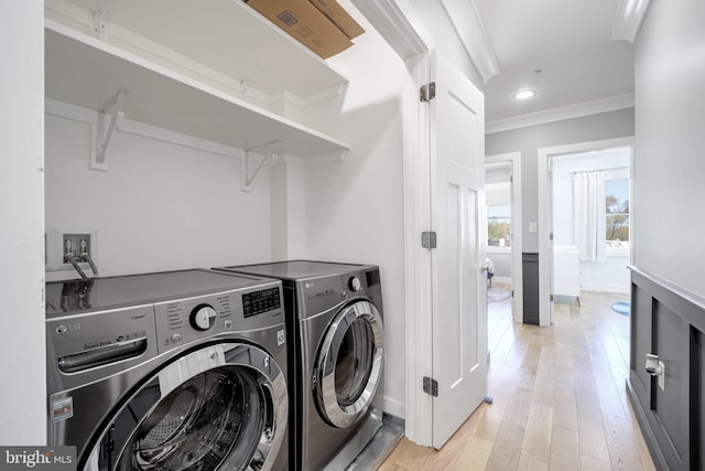 laundry room with ornamental molding, separate washer and dryer, and light wood-type flooring