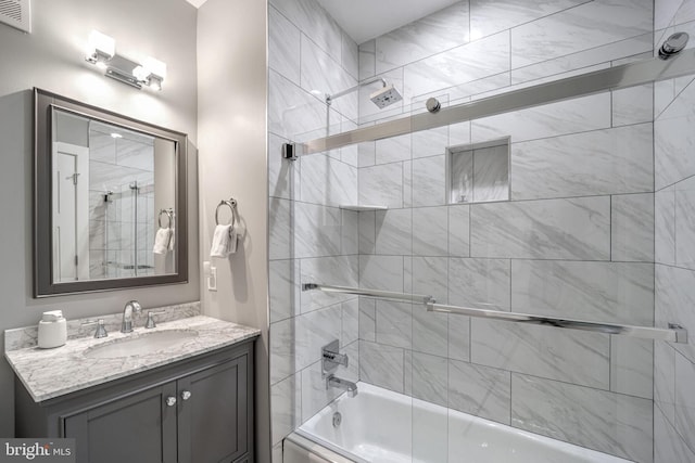 bathroom with vanity and shower / bath combination with glass door