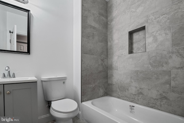 full bathroom featuring vanity, tiled shower / bath combo, and toilet