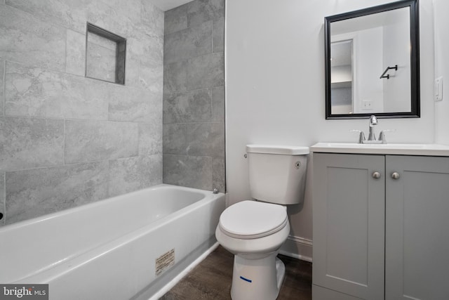 full bathroom with hardwood / wood-style floors, vanity, toilet, and tiled shower / bath