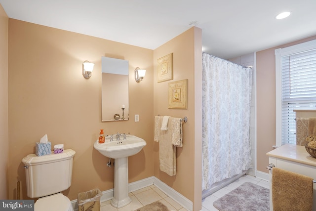 bathroom with a shower with shower curtain, tile patterned flooring, and toilet