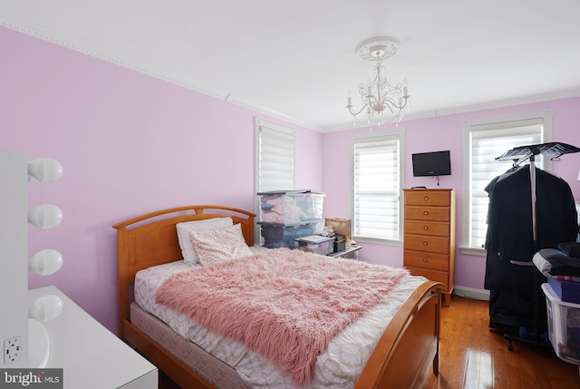 bedroom featuring wood-type flooring, a chandelier, and crown molding