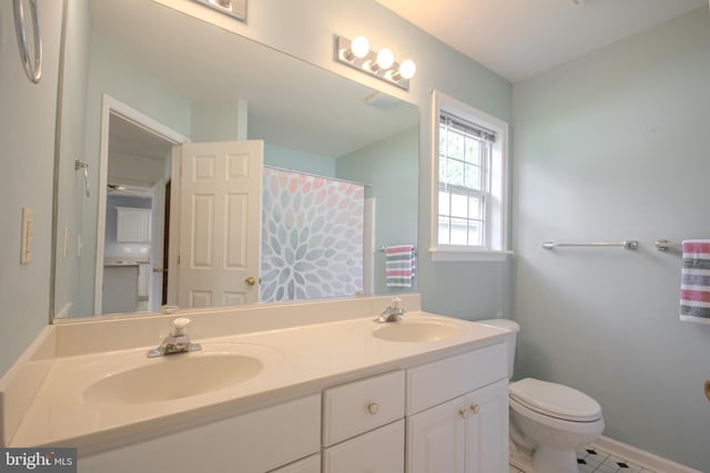 bathroom with toilet, vanity, and tile patterned floors