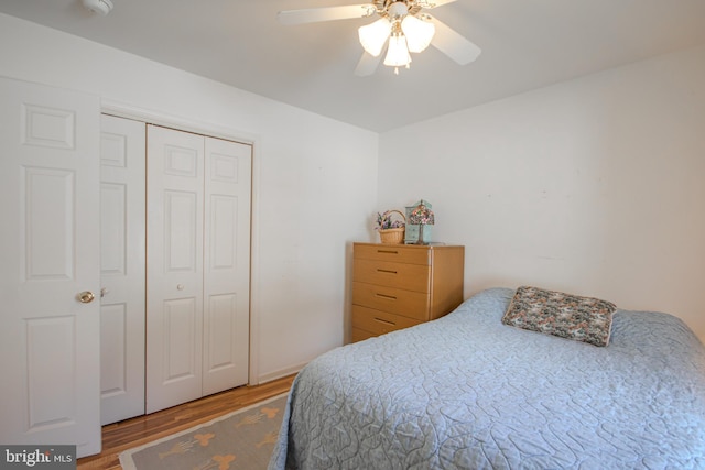 bedroom with hardwood / wood-style flooring, ceiling fan, and a closet