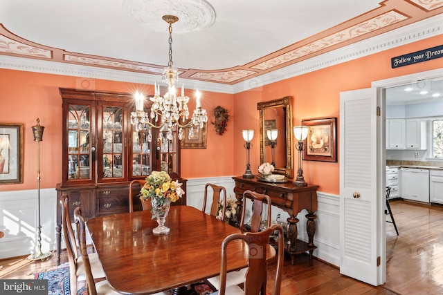 dining space featuring ornamental molding, hardwood / wood-style floors, and an inviting chandelier