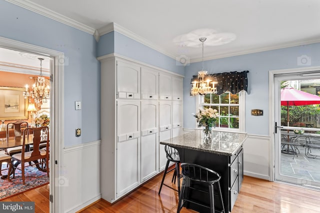 kitchen with a healthy amount of sunlight, a kitchen island, and white cabinets