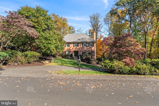 colonial home featuring a front lawn