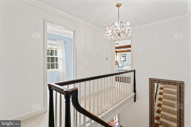 hall with ornamental molding, carpet, and a notable chandelier