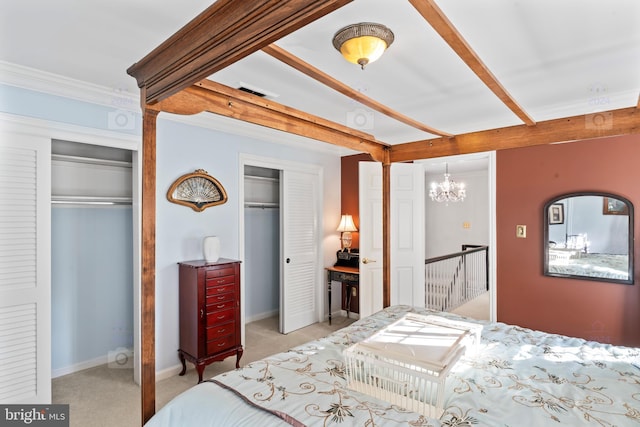 carpeted bedroom featuring crown molding, multiple closets, and an inviting chandelier