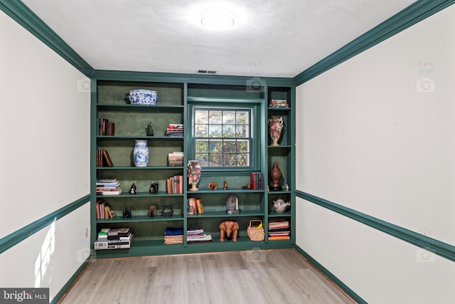 recreation room with ornamental molding and wood-type flooring