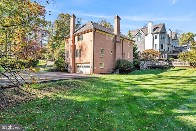 view of property exterior with a garage, cooling unit, and a lawn