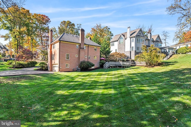 view of property exterior featuring central air condition unit and a lawn