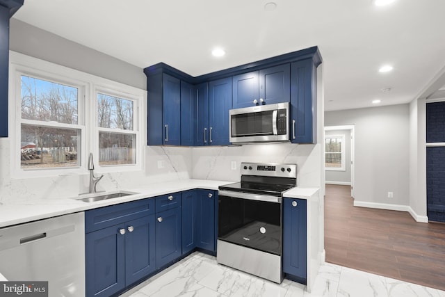 kitchen with a wealth of natural light, sink, stainless steel appliances, and blue cabinets