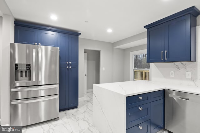 kitchen featuring blue cabinets, decorative backsplash, light stone countertops, appliances with stainless steel finishes, and kitchen peninsula