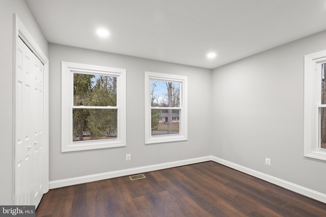 empty room with dark hardwood / wood-style flooring