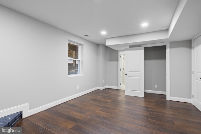 basement with dark hardwood / wood-style flooring