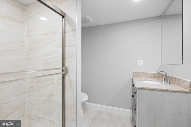 bathroom featuring vanity, toilet, and a shower with shower door