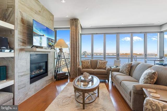 143 Waterfront St Unit 502, National Harbor, MD 20745 - living area with a tiled fireplace, wood finished floors, healthy amount of natural light, and recessed lighting