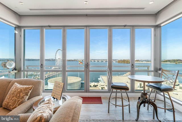 sunroom / solarium featuring a water view and a healthy amount of sunlight