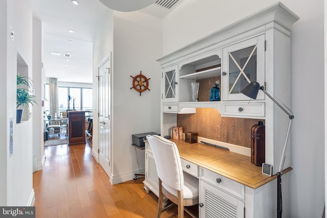 office space featuring light wood-type flooring and built in desk