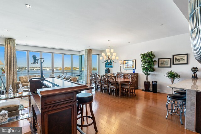143 Waterfront St Unit 502, National Harbor, MD 20745 - dining room with a chandelier, wood finished floors, baseboards, a water view, and recessed lighting