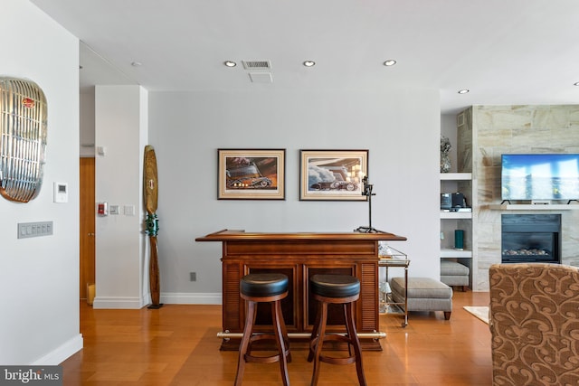 143 Waterfront St Unit 502, National Harbor, MD 20745 - indoor dry bar with wood finished floors, recessed lighting, a large fireplace, baseboards, and built in shelves