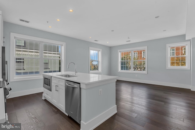 kitchen featuring dark hardwood / wood-style flooring, an island with sink, white cabinetry, sink, and stainless steel appliances