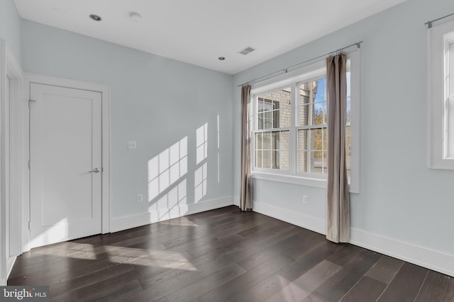 empty room with dark hardwood / wood-style flooring