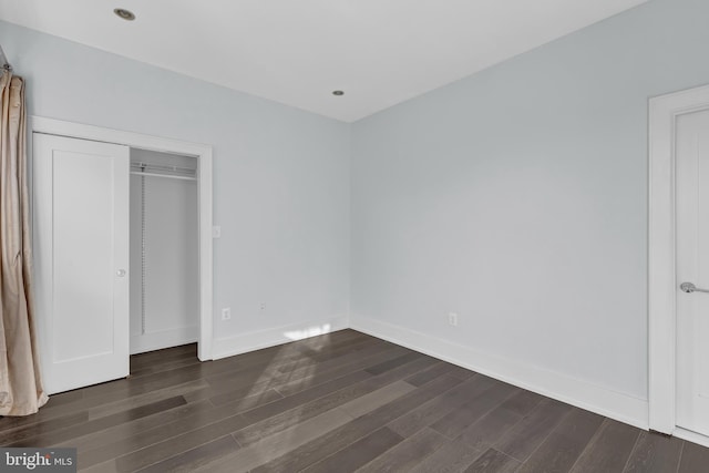 unfurnished bedroom with dark wood-style floors and baseboards