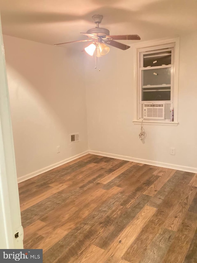 empty room featuring ceiling fan, wood-type flooring, and cooling unit