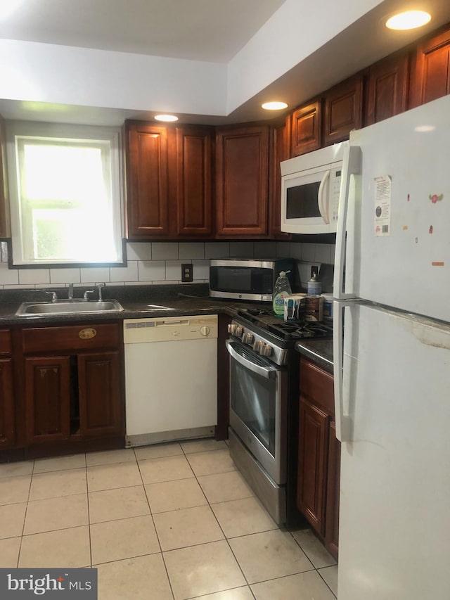 kitchen with tasteful backsplash, stainless steel appliances, sink, and light tile patterned floors