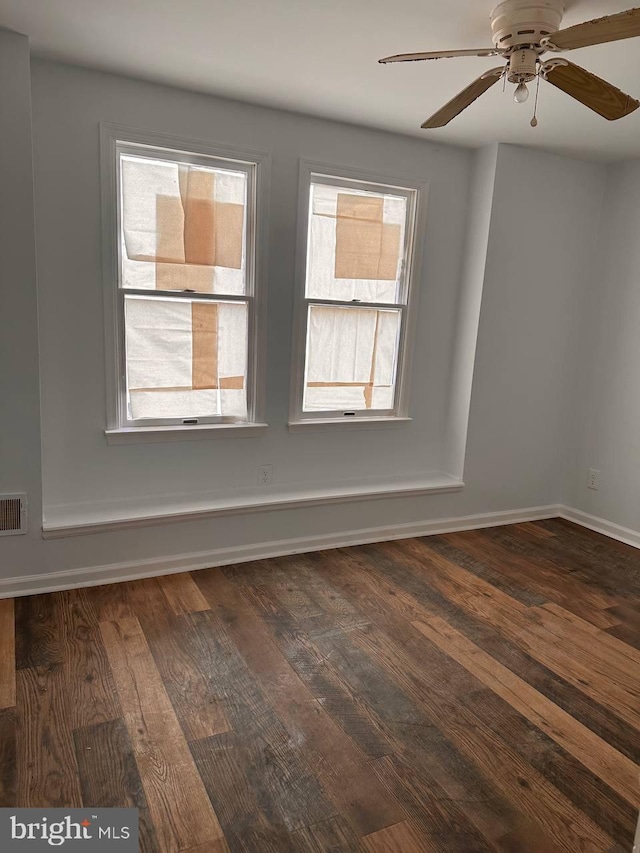 spare room featuring ceiling fan, a healthy amount of sunlight, and dark hardwood / wood-style floors