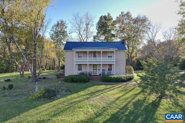 view of front facade featuring a balcony and a front yard