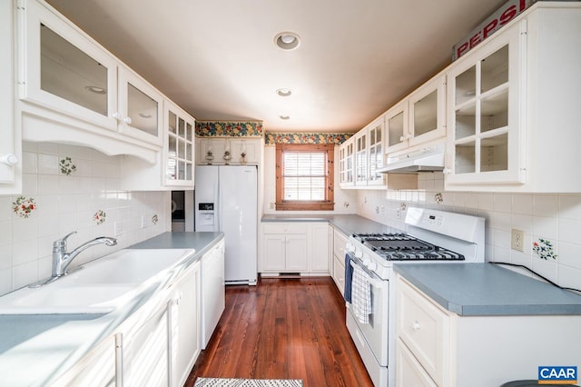 kitchen featuring white appliances, sink, white cabinets, decorative backsplash, and dark hardwood / wood-style floors