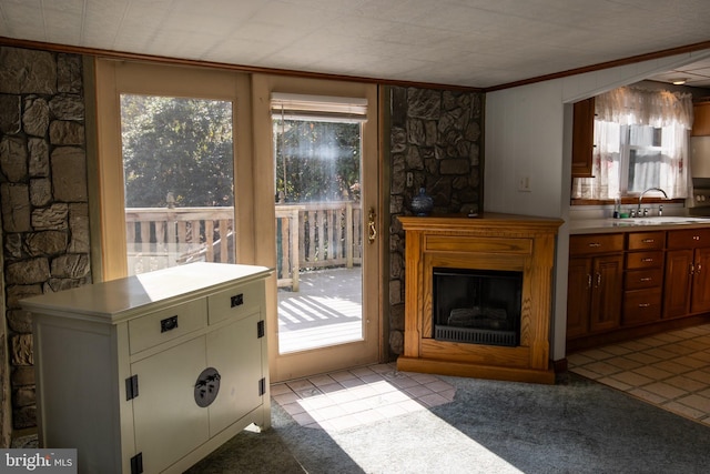 unfurnished living room featuring light colored carpet, sink, and ornamental molding