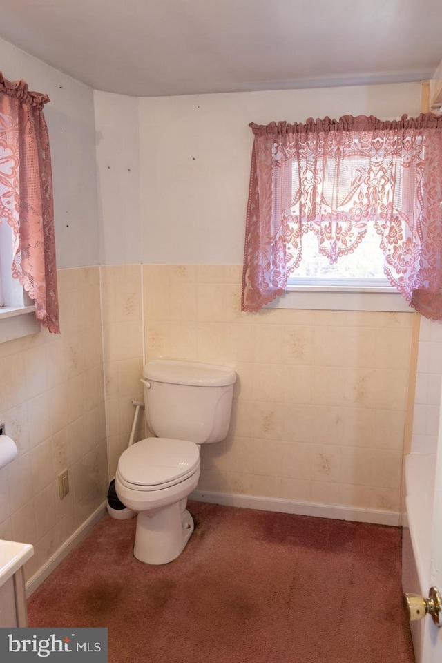 bathroom with vanity, toilet, and tile walls