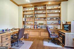 office area with dark wood-type flooring and built in desk