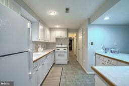 kitchen featuring white cabinets and white appliances