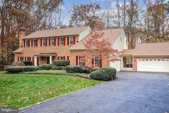 colonial home with a garage and a front yard