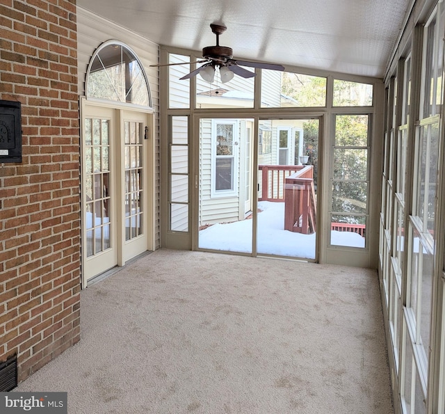 unfurnished sunroom with lofted ceiling, plenty of natural light, and ceiling fan