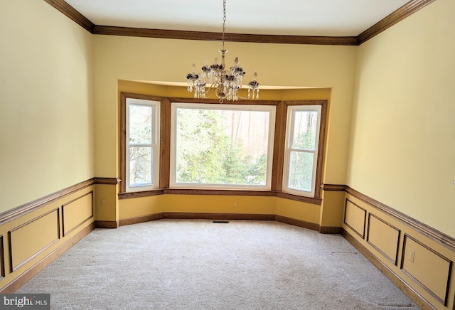 carpeted empty room with crown molding and a notable chandelier