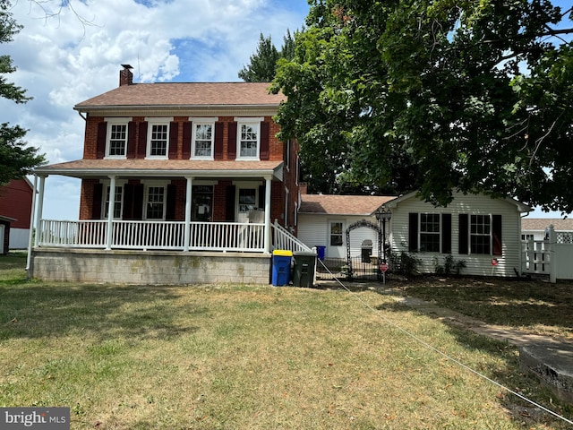 colonial home with a porch and a front lawn