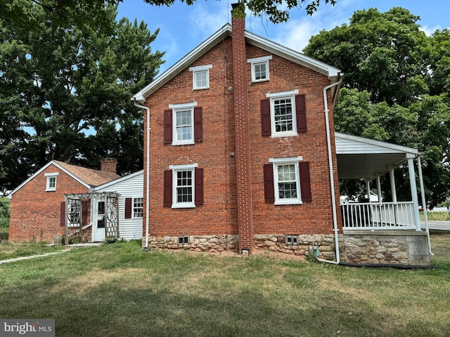 view of side of home featuring a yard and a porch