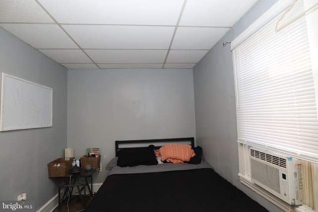 bedroom with a paneled ceiling and cooling unit