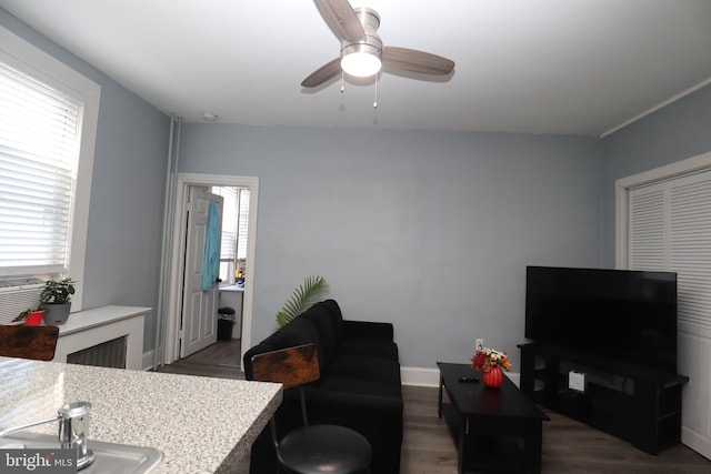 living room with dark hardwood / wood-style floors and ceiling fan