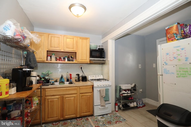 kitchen featuring range hood, sink, white appliances, and tasteful backsplash