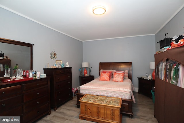 bedroom with crown molding and light hardwood / wood-style flooring