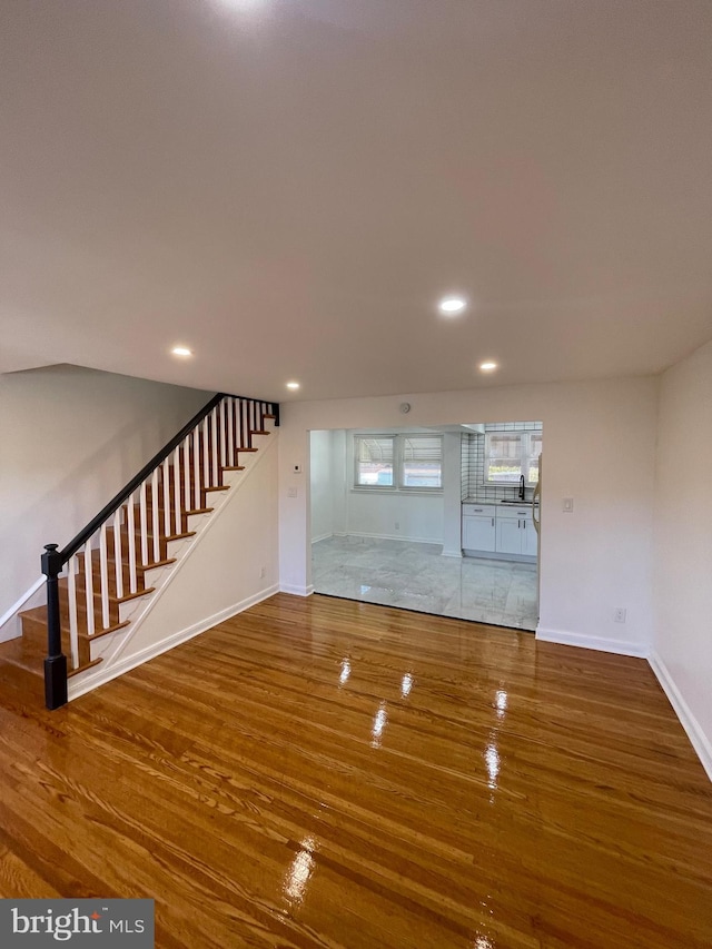 unfurnished living room featuring sink and wood-type flooring